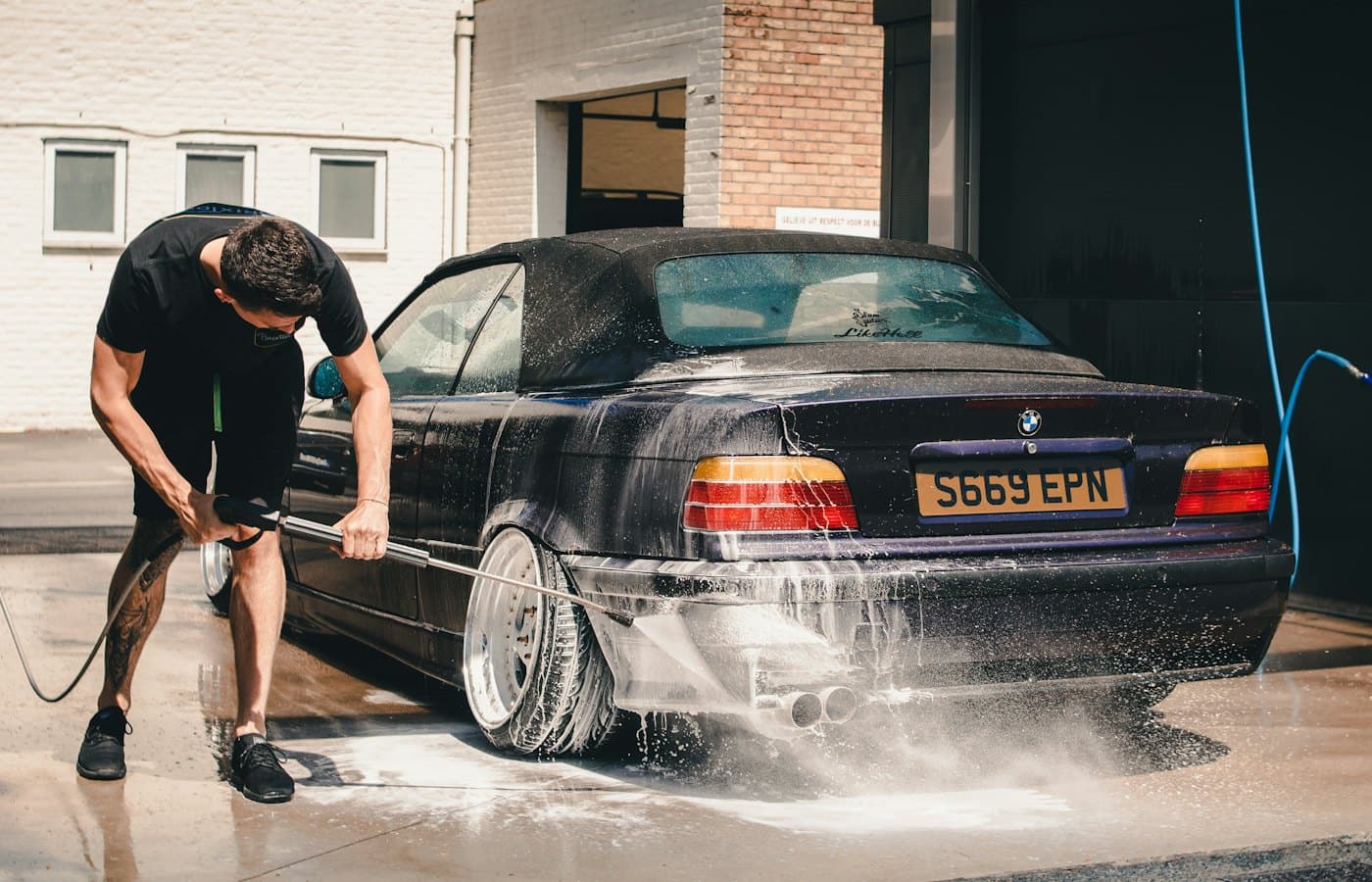 Detailer foaming a car during a professional wash